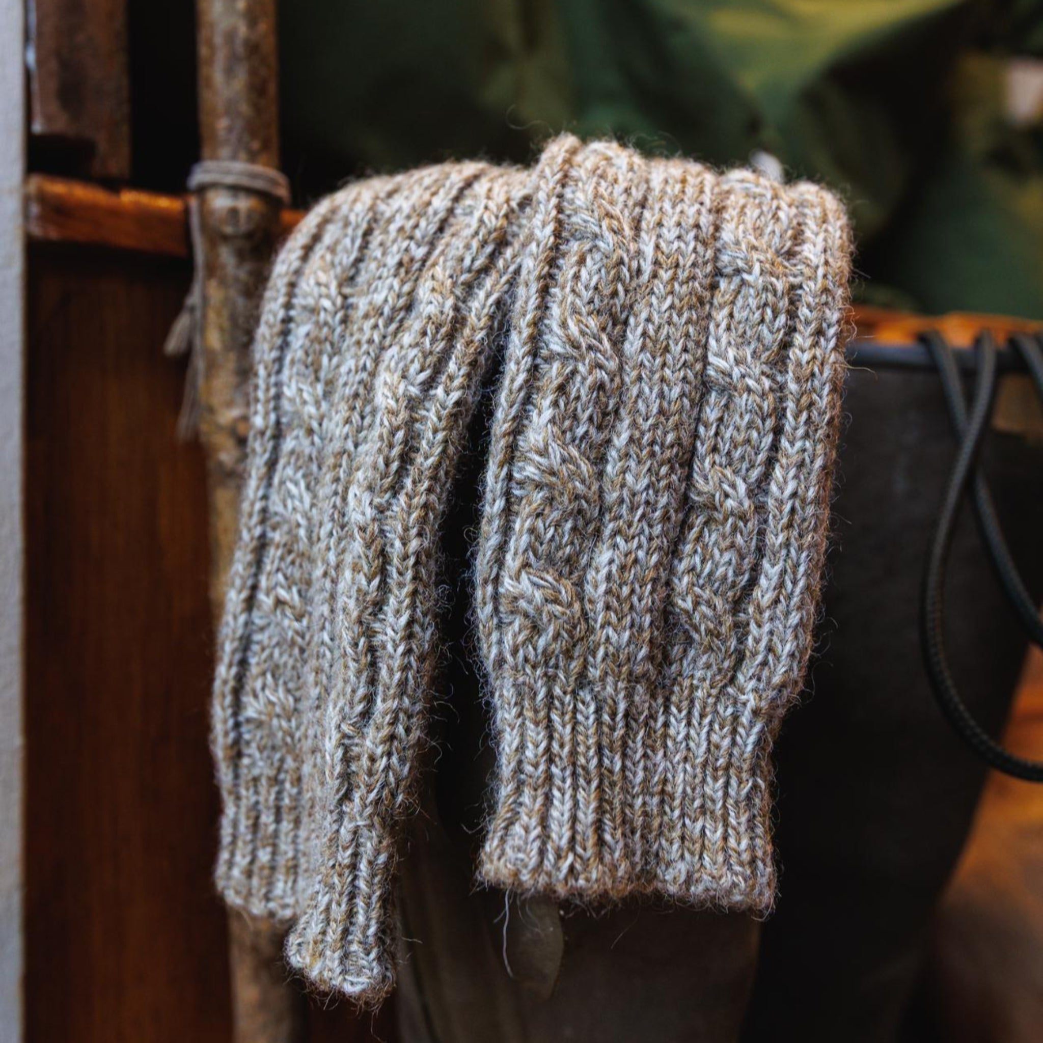 Pair of knitted socks hanging on a wellies in a country boot room