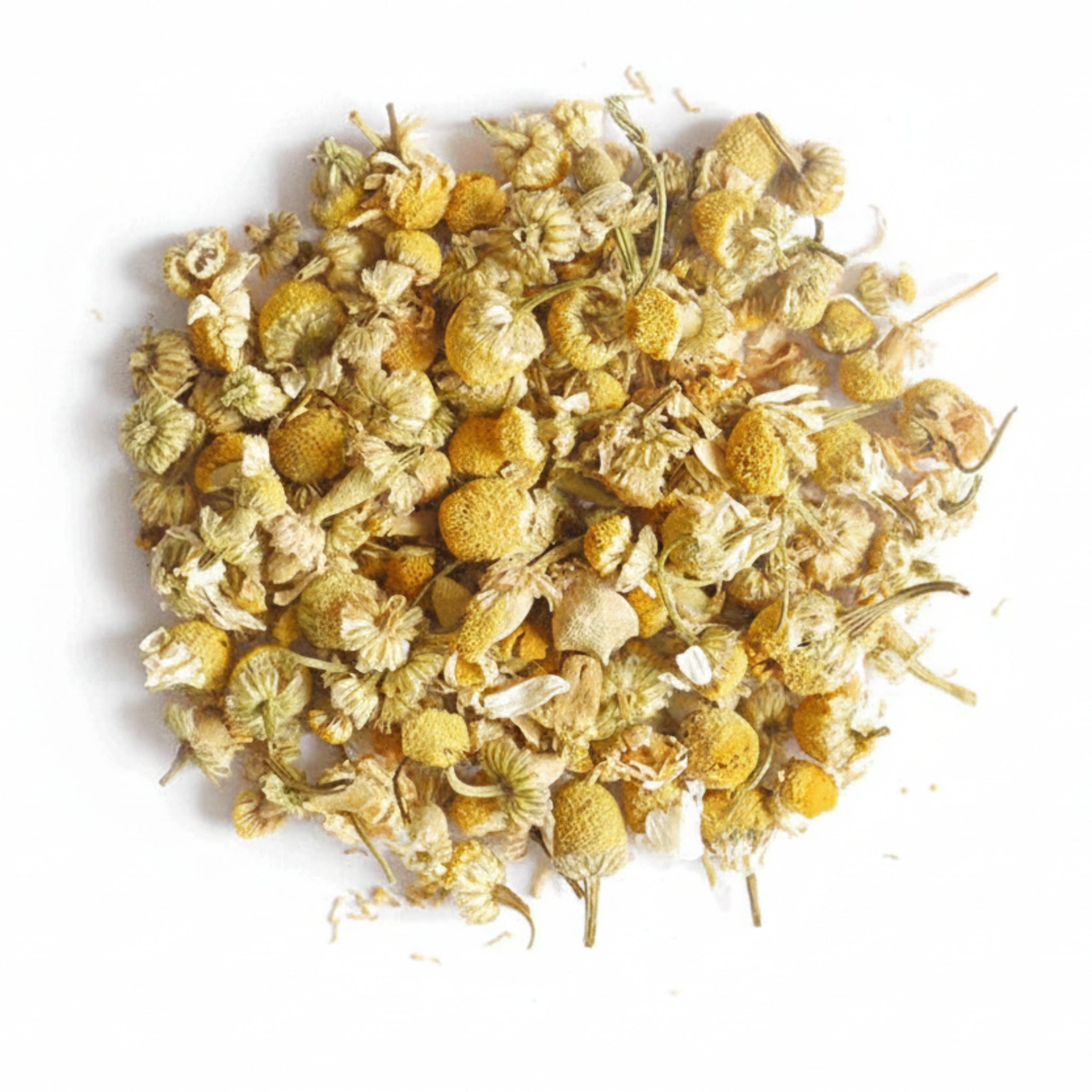 A pile of dried chamomile flowers, showing their yellow and cream tones on a white backgrond.